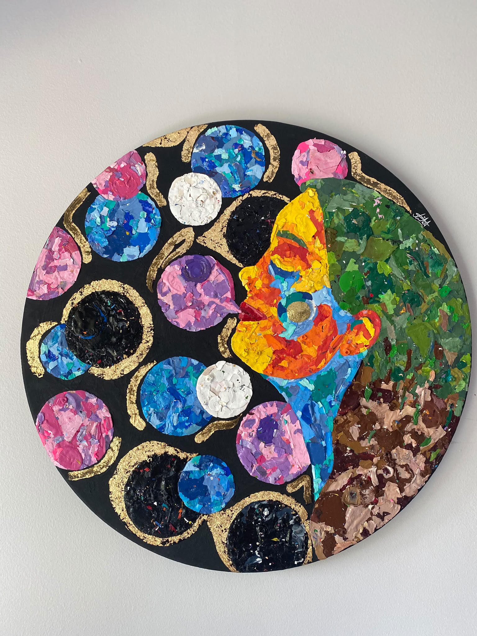 Round acrylic and paint-chip portrait titled Wonder, with a colourful profile, pink and blue circles, and golden arcs.