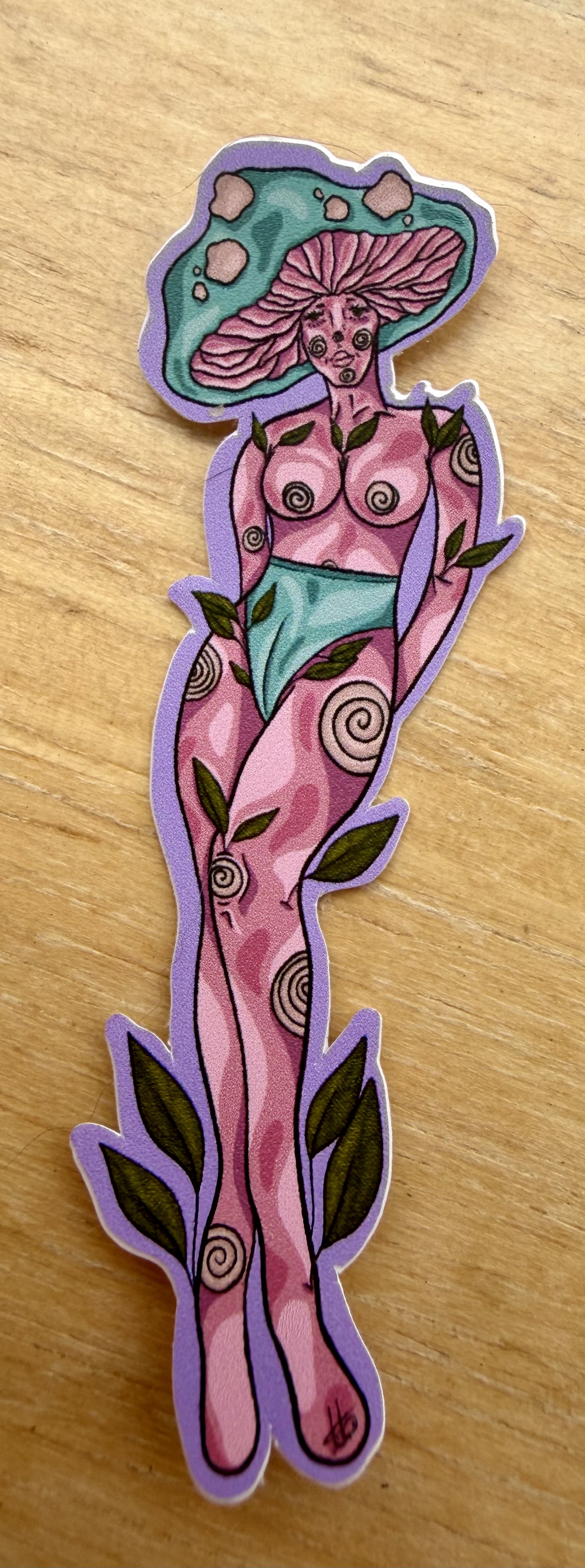 Mushroom Madness sticker with a tall pink figure, mushroom cap, and small decorative details.