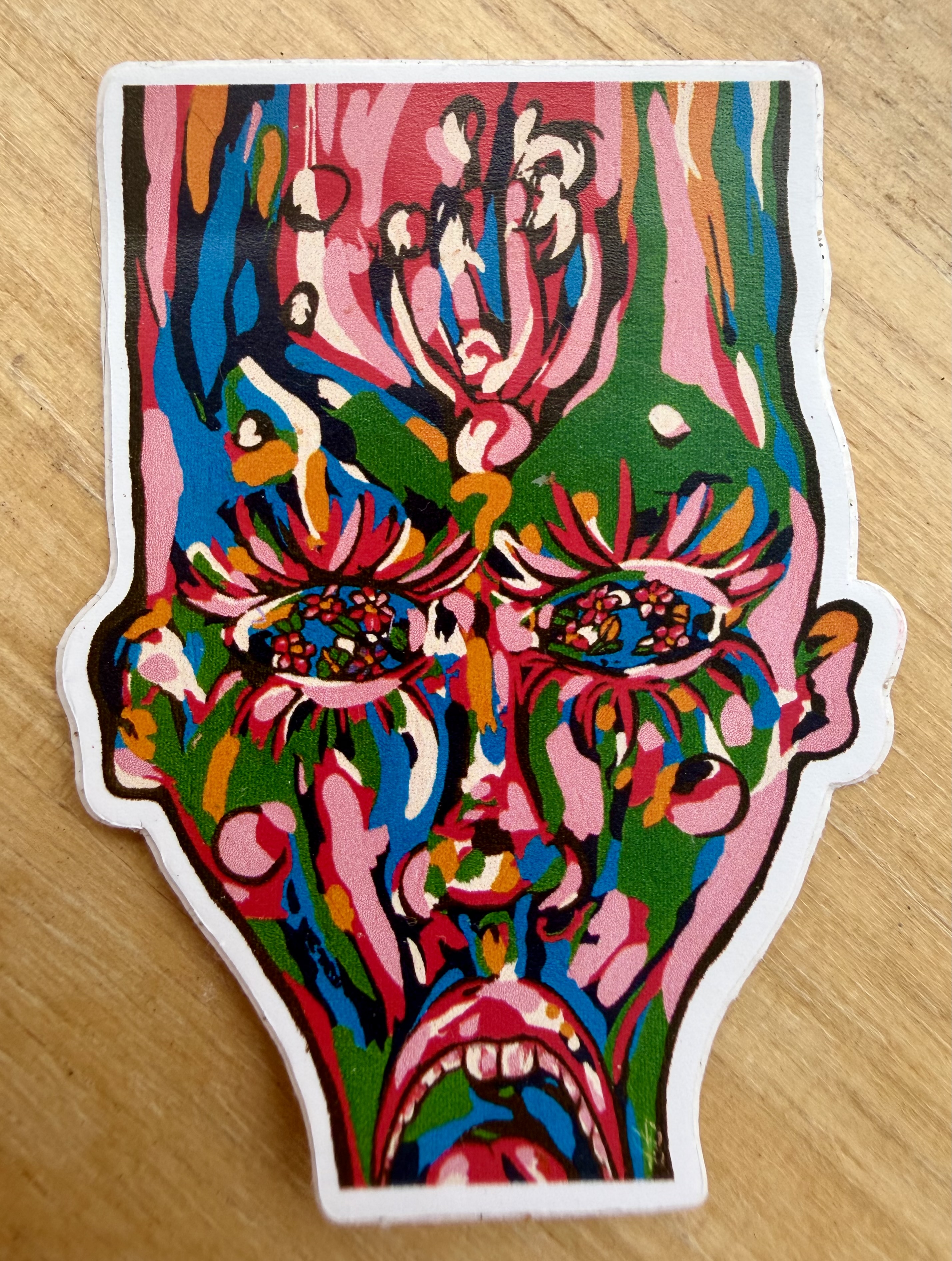 Why sticker with a colorful expressive face, red background marks, green eyes, and bold black lines.